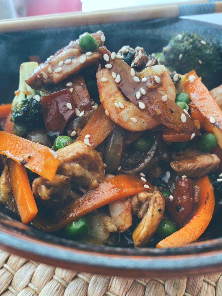El wok de pollo, gambas y verduras